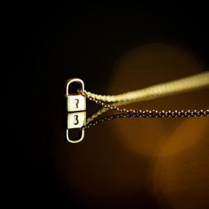 Minimalist silver lock pendant with yellow gold plating.